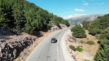 Girit 'teki ücra bir dağ ormanından geçen tek bir arabanın insansız hava aracı görüntüsünde yalnızdım. Özgürlük, tecrit keşfi ve uzun bir yolculuğun yalnızlığını taşır.