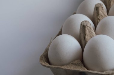 Perakende ürün sergisi: Standart bir süpermarket paketleme tepsisinde taze, beyaz yumurtalar. Kompozisyon, temel gıda malzemeleri, stok fotoğrafları ve market alışverişi temaları için temiz ve net bir görüntü sağlıyor.