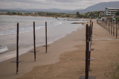 Yaz tatili kalıntıları ıssız sahilde unutulmuş duruyor. Bu görsel güçlü bir şekilde geçiş, kapanış, yalnızlık, turizm düşüşü ve değişen zaman temalarını iletir