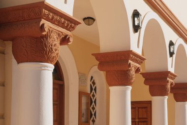 Çok güzel detaylandırılmış sütunlarda zarif oymalar ve beyaz ve terracotta renklerinin bir karışımı var. Yapı, gün ışığında sıcak bir ortam yaratıyor..