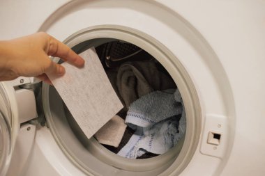 Çamaşır makinesinin variline çamaşır çarşafı ile bir renk yerleştirmek. Yıkama döngüsü sırasında boya transferinin önlenmesi ve kıyafetlerin çalışan renklerden korunması.