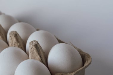 Kutudaki beyaz tavuk yumurtası, gıda fiyatlarının ve sebze fiyatlarının yükselişini simgeliyor. Bu resim piyasa enflasyonu, tüketici harcamaları ve perakende envanter hakkında makaleler göstermek için uygundur