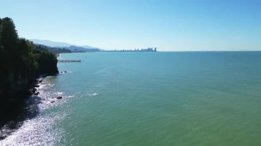 Güneşli bir günde Batumi 'nin uzak hava manzarası. 4K yatay insansız hava aracı görüntüleri açık havada şehrin ufuk çizgisini, ikonik binaları ve sokakları gösteriyor..