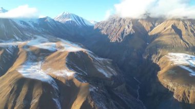 Açık güneş ışığı altındaki kış dağları. 4K insansız hava aracı görüntüleri Gürcistan 'ın hafif karla kaplı dağlık arazilerini gösteriyor. Parlak ve sakin bir günde dramatik bir doğal manzara ortaya çıkıyor..