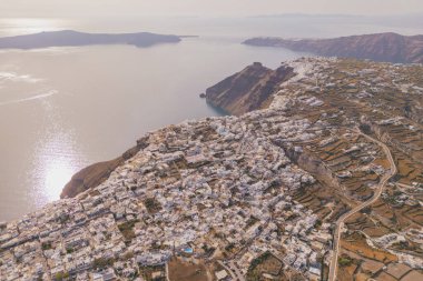 Santorini 'deki hava panoramik manzarası. Volkanik kayalıklardaki geleneksel beyaz binalar sakin Akdeniz manzaralı.
