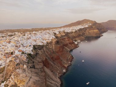 Santorini adasında Akdeniz mavisi havası var. Geleneksel mavi kilise kubbeleri turkuaz denize ve berrak gökyüzüne karşı. Sükunet, yaz atmosferi ve Yunan ada renkleri kavramı.