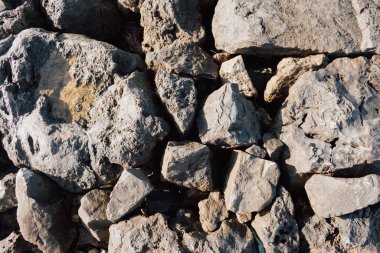 Kuru, eski kireçtaşı kayaları, arka plan deseni, sert yaz güneşi ve gölgeler altında. Soyut tasarım ve inşaat konsepti için kaba jeolojik malzeme