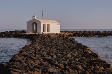 Resimli inzivaya çekilme: Ege 'ye uzanan dar bir kaya iskelesinde beyazlatılmış şapel. Çekici sahne sükunetin, deniz tarihinin ve kıyıların engebeli güzelliğinin özünü yakalar.