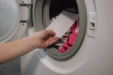 Yenilikçi renk tuzağı çarşafı çamaşır makinesi varilinde çeşitli kıyafetlerle kapanıyor. Modern ev hijyeni için basit bir çözüm, çamaşır yıkama sırasında tesadüfi renk bozulmasını önlemek.