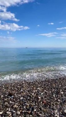 Dikey çekim: Girit kıyısında güzel turkuaz Ege deniz dalgaları, ufukta ufukta görünen uzak askeri deniz gemileri silueti, Yunan Akdeniz manzarası