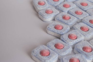 Minimalist tasarım: saf beyaz arka planda bulaşık yıkama tabletleri. Bu düz kompozisyon temizliği, sadeliği ve modern ev hijyenini sembolize eder. Sunumlar için harika.