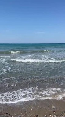 Güneşli havada güzel sakin denizin dikey görüntüsü, turkuaz suyla huzurlu Akdeniz manzarası