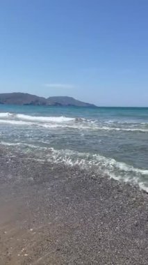 Güneşli çakıl taşları, zümrüt sığlıkları ve derin mavi suların yer aldığı dikey kıyı manzarası, parlak, ışıl ışıl detaylarla huzurlu bir Akdeniz havası yaratıyor. Sihirli Girit sabahı. Yüksek kalite 4k görüntü