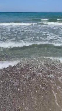 Dikey çekim: beyaz köpüklü deniz dalgaları çakıl taşlı plajları siliyor, uzak dağ sıralarına yayılıyor, Girit kıyıları