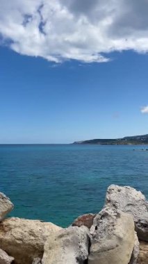 Dikey panelleme: kayalık sahil seti, turkuaz Akdeniz Körfezi manzarası, manzaralı Yunan dağlık ufuk çizgisi