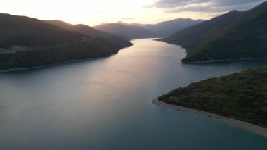 Zhinvali Su Rezervuarı 'nın yatay dron panoraması. Zümrüt dağları ve Gürcistan zirveleriyle çevrili turkuaz su. Seyahat ve ekoloji için sinematik manzara. Yüksek kalite 4k görüntü