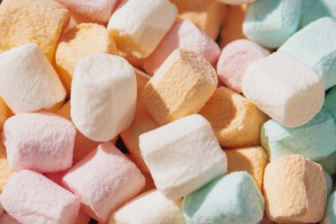 Renkli şekerlemelerin üst görüntüsü yumuşak bir şeker dokusu yaratıyor. Pastel pembe ve beyaz tatlılar tozlu yüzey ile tasarım için tatlı kadife bir arka plan sunar.