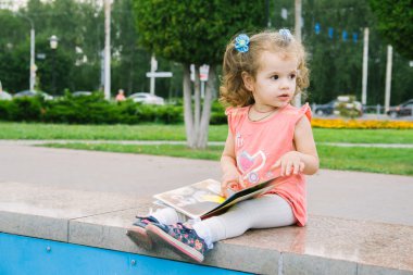 Küçük bebek kız onu en sevdiğim kitap oturan okuma