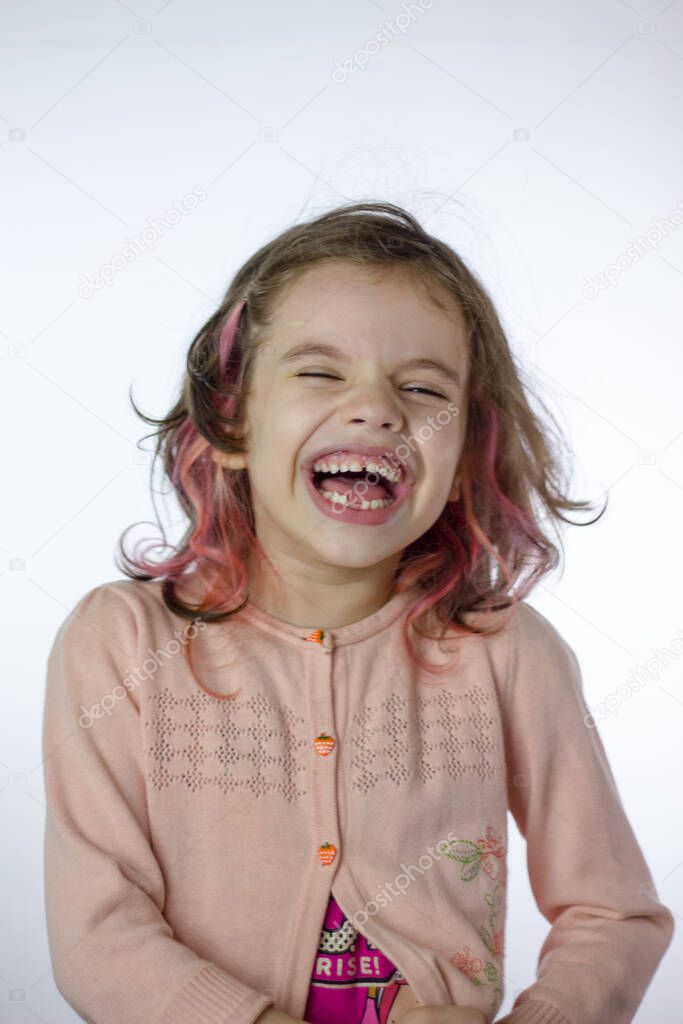Adorable little kid girl laughing on a white
