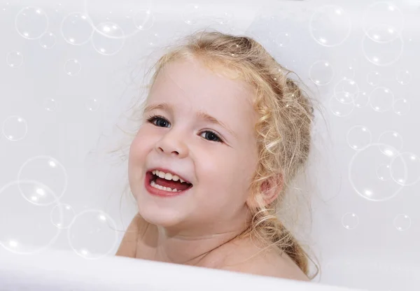 Smiling child girl having soapy bath with foam and bubbles at home close-up — Stock Photo, Image