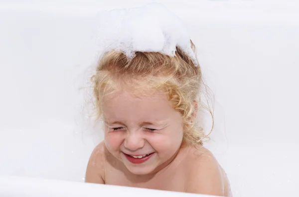 Smiling child girl having soapy bath with foam at home close-up — Stock Photo, Image