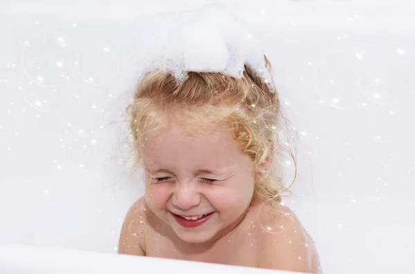 Smiling child girl having soapy bath with foam and bubbles at home close-up — Stock Photo, Image