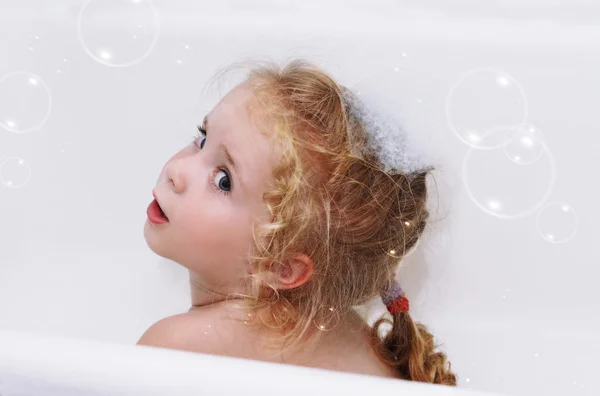 Sorrindo menina criança tendo banho ensaboado com espuma e bolhas em casa close-up — Fotografia de Stock