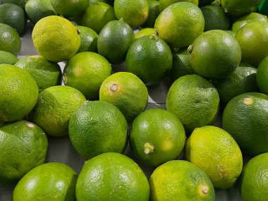 Bir markette sergilenen taze yeşil limon ve narenciye tohumu.