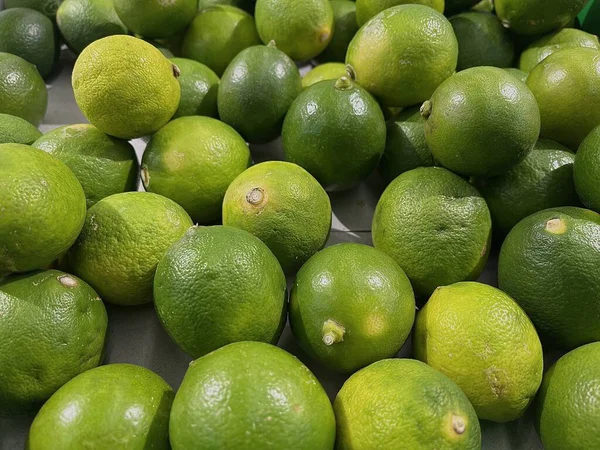 Bir markette sergilenen taze yeşil limon ve narenciye tohumu.