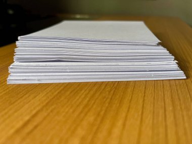 Ahşap bir masa yüzeyinde duran bir yığın Beyaz Kağıt Çarşaf