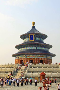 Turistler, güneşli bir günde geleneksel Çin mimarisini sergilemek üzere Pekin, Çin 'deki Cennet Tapınağı' ndaki İyi Hasat İçin Dua Salonu 'nun etrafında toplandılar..