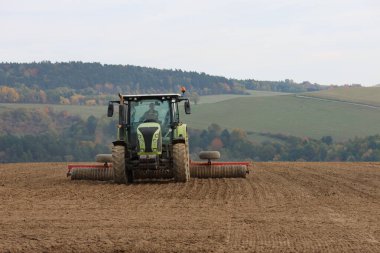 Kırsal alanda tarımı yapan traktörün ön görüntüsü, kırsal alanda tarımsal faaliyeti ve tarım makinelerini temsil ediyor
