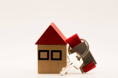 Anahtar ve beyaz geçmişi olan oyuncak evi bir emlak ajansı konsepti.