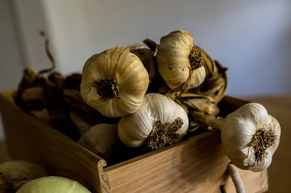Gösterişsiz natürmort yaşam ön planda bir avuç sarımsaktan oluşur.