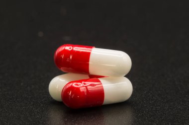 Makrofotografa de un grupo de pastillas rojas y blancas con fondo negro