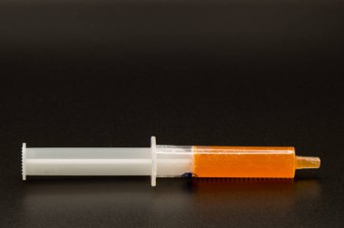 Portakal şurubuyla dolu bir şırınganın yan görüntüsü, çocuk ilacı konsepti