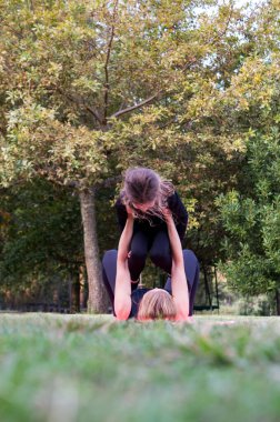 Anne parkta oğlunu kaldırırken yerde yatıyor.