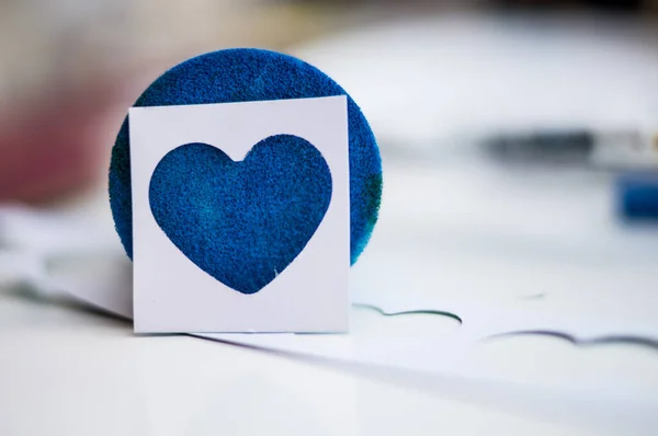 Gri arkaplanda kağıt olan mavi kalp.