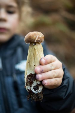 Parmağında mantar olan küçük bir çocuk.