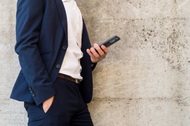 Sırtında telefonla takım elbiseli genç ve yakışıklı bir iş adamı..