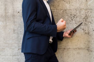 Genç adam şehirde tablet kullanıyor.