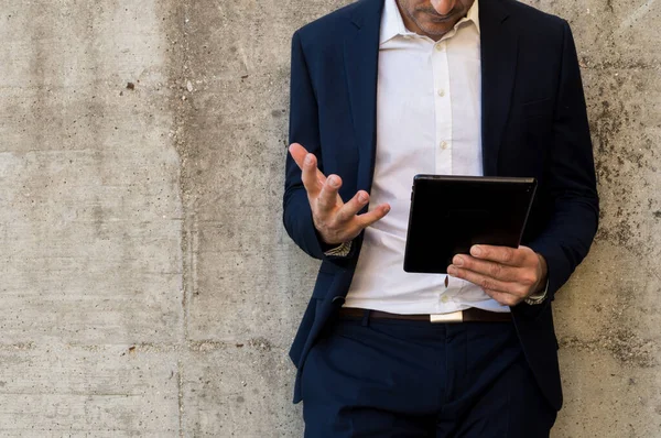 Takım elbiseli bir iş adamı açık hava görüntülerini tartışıyor.