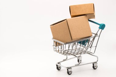 Beyaz arka planda karton kutular olan alışveriş arabası.