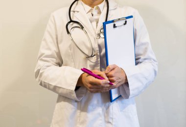 Kadın doktor not defterine notlar yazıyor.