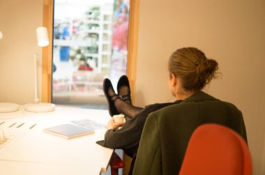 Kadın, Parlak Pencere 'ye Bakan Ayakla Rahatlamış Kahve Molasından Hoşlanıyor