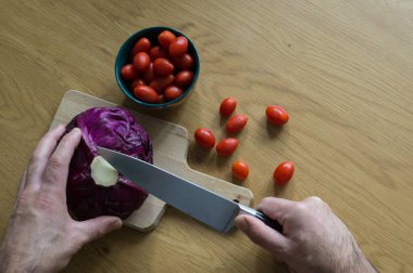 Domates kasesinin yanında Mor Lahana Kesen Eller