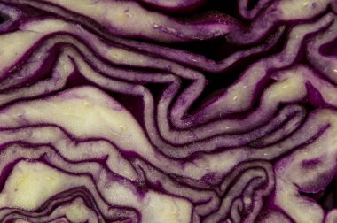 Makro fotoğrafçılık kırmızı lahana yapraklarının ritmik ve dalgalı çizgilerine odaklanarak doğal bir soyut arkaplan oluşturur..