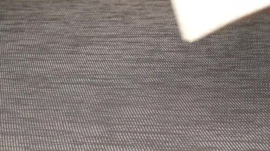 Bir el, gri bir yüzeye kahverengi çatılı beyaz bir karton evi dikkatlice yerleştirir. İlk kez ev satın alma, ipotek başvuruları, çevre dostu bina ve emlak pazarlama için mükemmel..