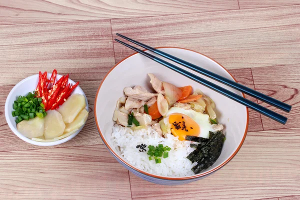 Rice är toppad mjuk koka ägg och stekt fläsk i japansk stil som "Oyakodon" på trä. Side View. — Stockfoto