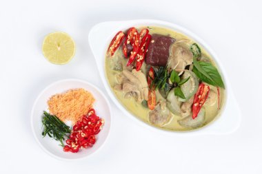 Hindistan cevizi sütünde yeşil tavuk köri kıyılmış kurutulmuş karides olarak garnitür ile servis, dilimlenmiş kırmızı biber, dilimlenmiş kaffir kireç yaprakları ve beyaz arka plan üzerinde yeşil limon.